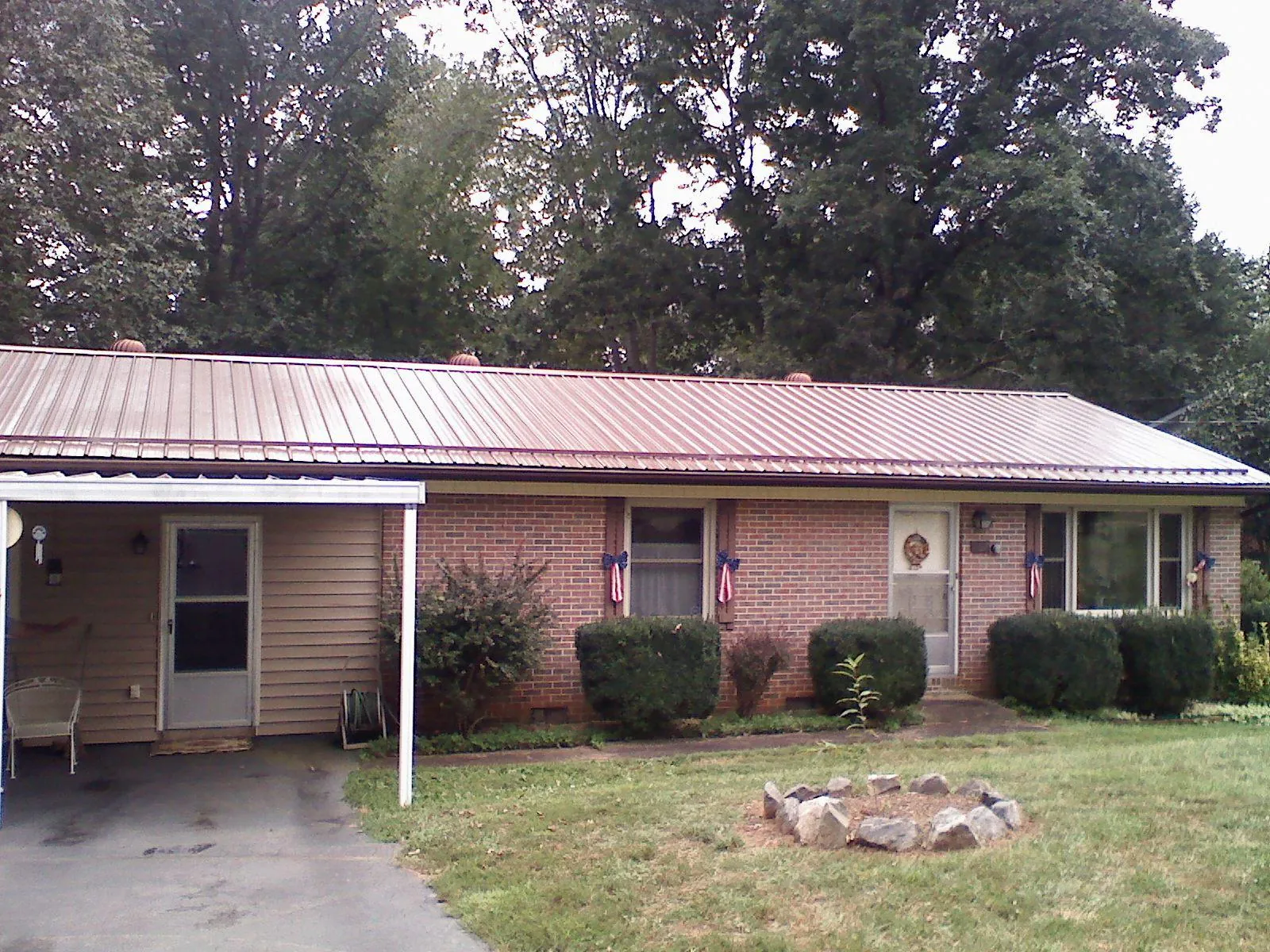 Bronze metal roof and carport on a brick ranch home — Roof Repair work by our crew in Clinton