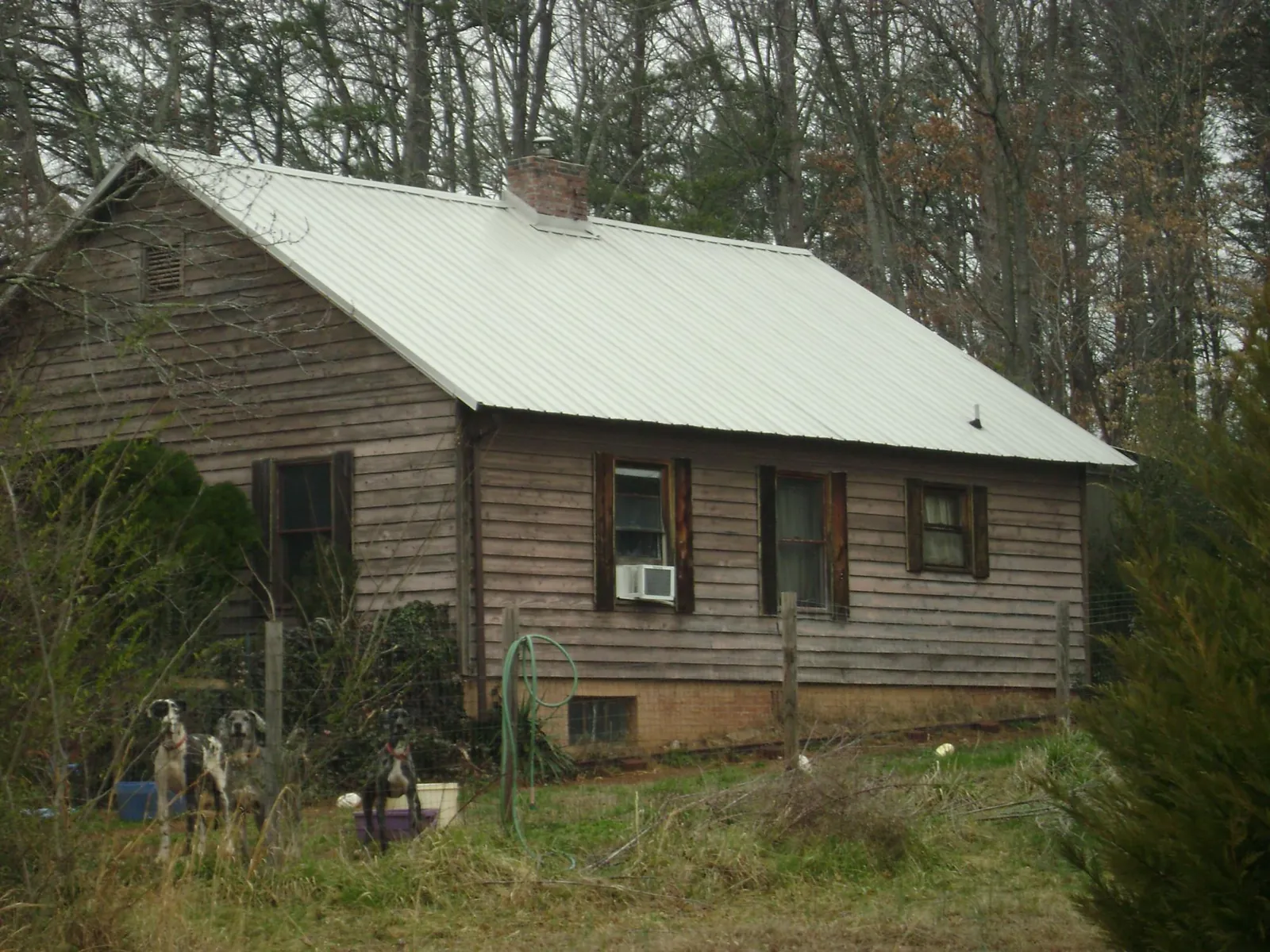 White metal roof on an old wood sided farmhouse, from a Metal Roof Installation job in Clinton